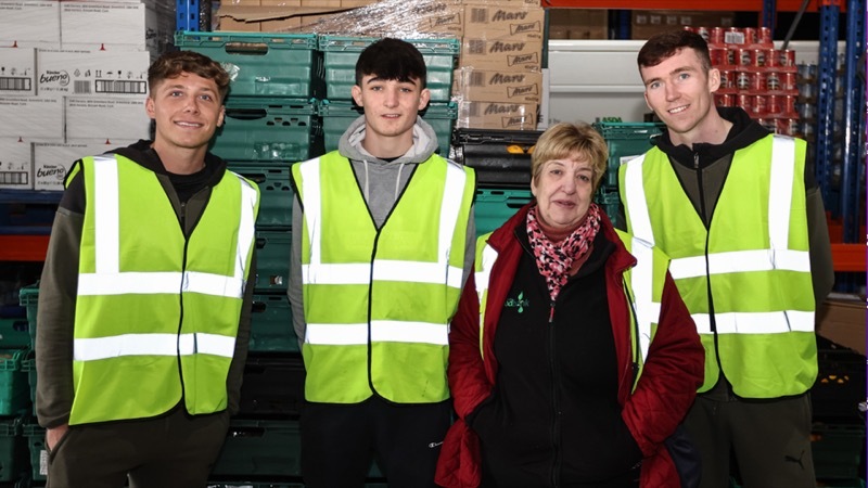 REDS AGAINST HUNGER: Barnsley FC players Aiden Marsh and Conor Grant with staff at the Foodbank last week.