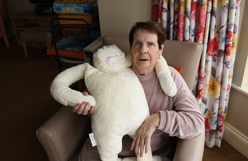 CUDDLE AWAY STRESS: 86 year old Eileen Marsden tries out one of the ‘Hug’ comforters at Mapplewell Manor Care Home  -a  toy with a true beating heart.  Picture: Wes Hobson. PD091954.