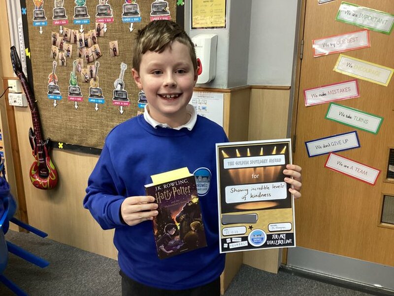 Generous Seth Buchan with a certificate and book his school gifted him.