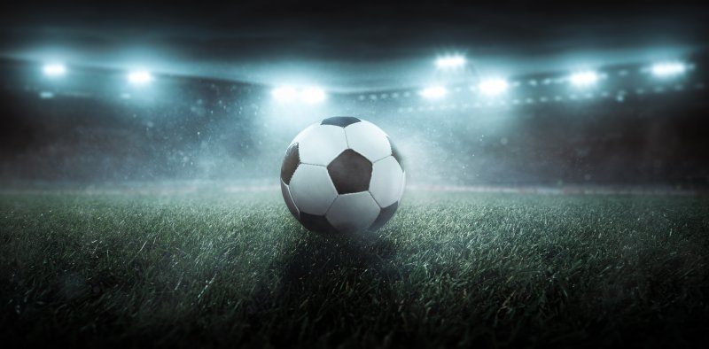 Football on pitch stadium lights on, arty shot Stock Image